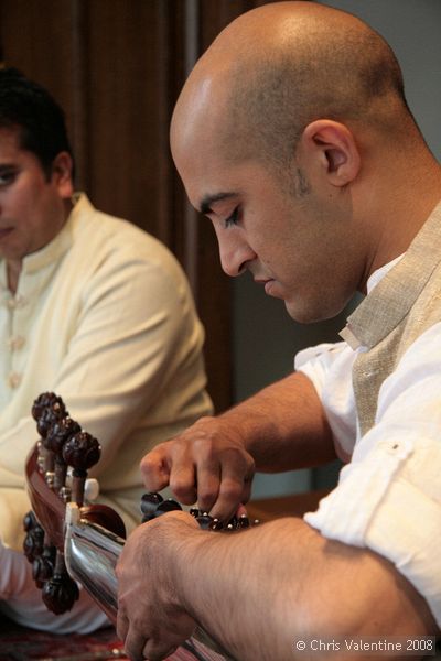 Tarun Jasani tunes his Sarod. There are two sets of tuning pegs, the further ones for the longer strings, which are spaced further apart, and the closer ones for a second set of strings that are close together.