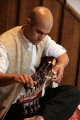 Tarun Jasani tunes his Sarod. There are two sets of tuning pegs, the further ones for the longer strings, which are spaced further apart, and the closer ones for a second set of strings that are close together.